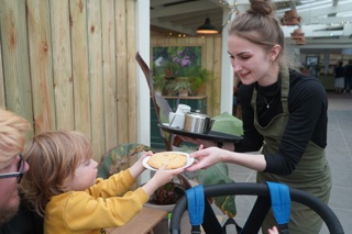 Jen in Heligan Kitchen and Bakery serving tea and a biscuit