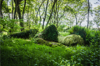 Mud Maid in spring and summer surrounded by greenery